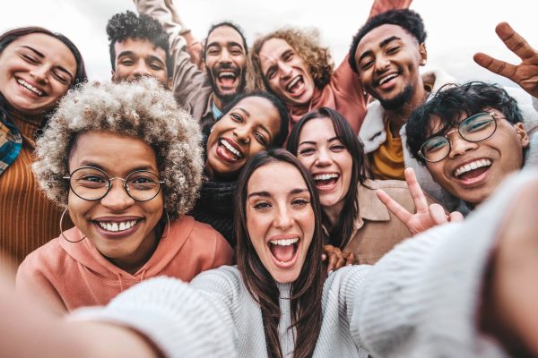 Multicultural community of young people smiling together at camera